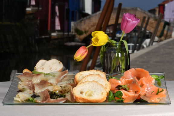 Piatto con bis di marinati con salmone e ricciòla serviti con crostini di pane